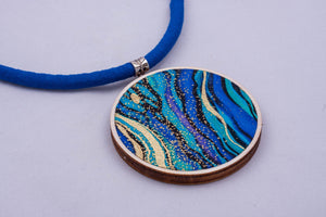 Necklace made from colorful fabric on light wood base