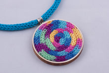 Statement necklace made with colorful yarn on light wood base