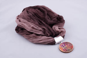 Brown scarf with pendant made with fabric on light wood base (shades of brown)