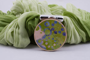Light green scarf with pendant made with fabric on light wood base (shades of light green)