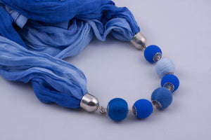 Blue scarf decorated with beads and beads covered by yarn (shades of blue)
