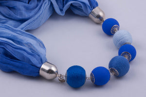 Blue scarf decorated with beads and beads covered by yarn (shades of blue)